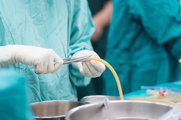 surgeon prepping a surgical site drain